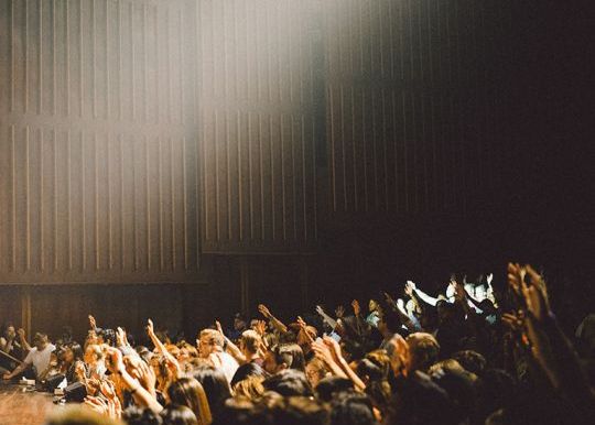 people worshiping in an auditorium 